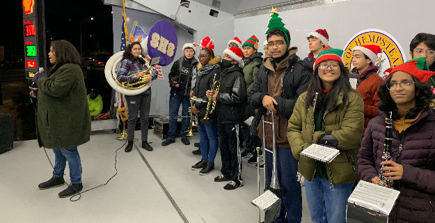 band donning christmas hats about to perform in a truck parked at a shell station