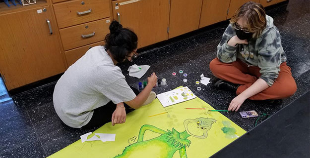Students Decorating a Grinch Poster For The Hallway