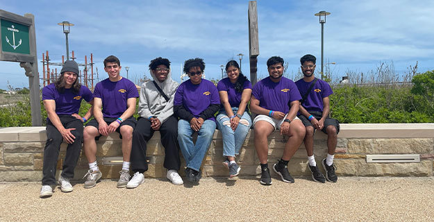 Students sitting on a rock wall