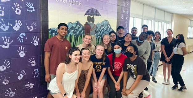 Students in front of the hallway mural
