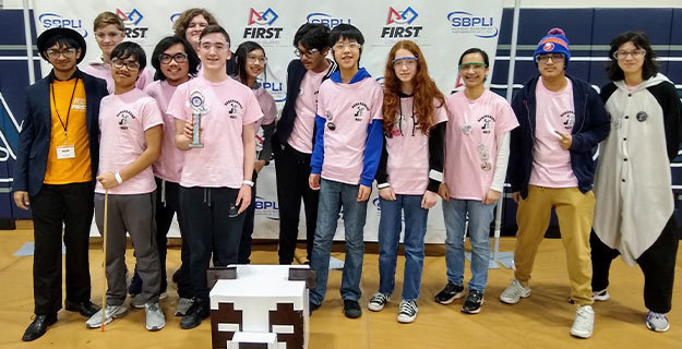 Robotics team standing together and smiling