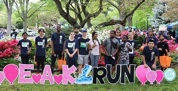 Students behind a sign that says EAK RUN