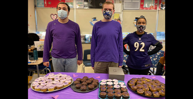 Students and staff wearing purple at the bake sale