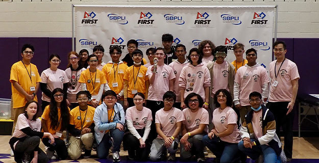 The district's robotics team smiling at the camera