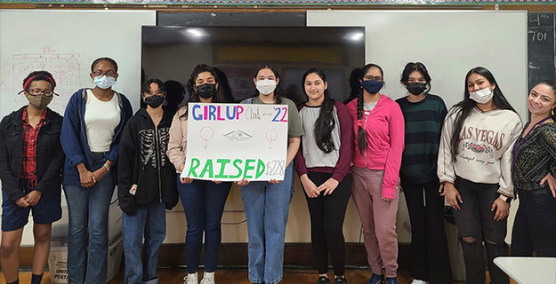 Girl Up Club with a hand-made sign