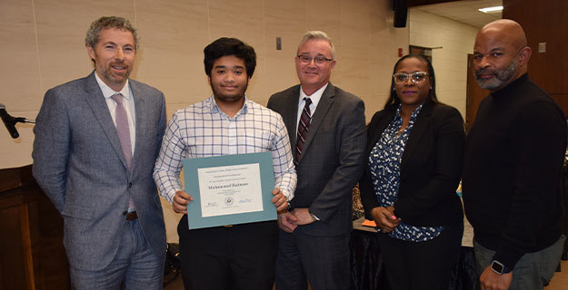 BOE members with a student holding a certificate