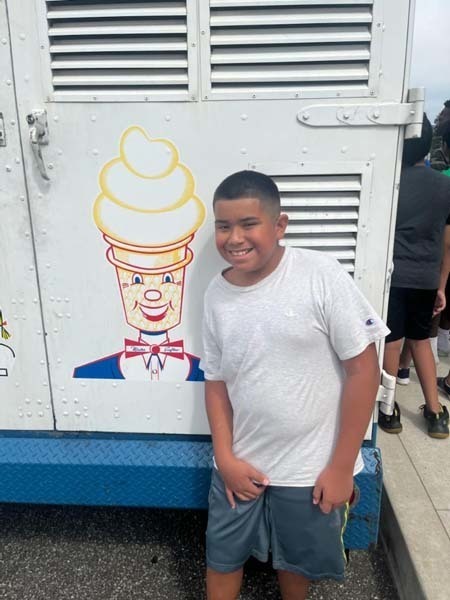 Student smiling next to an ice cream truck