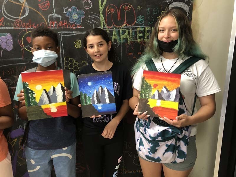 Students holding their artwork