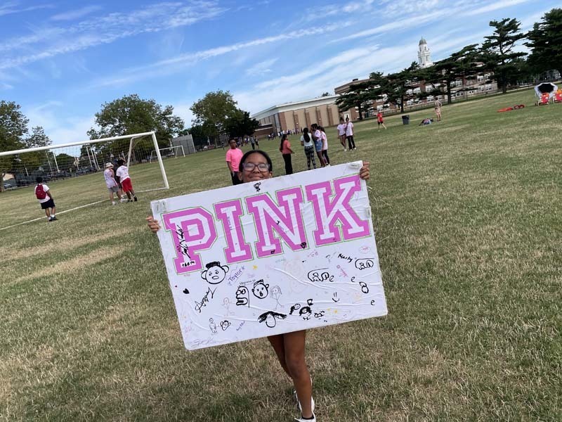 Student holding a sign that says PINK
