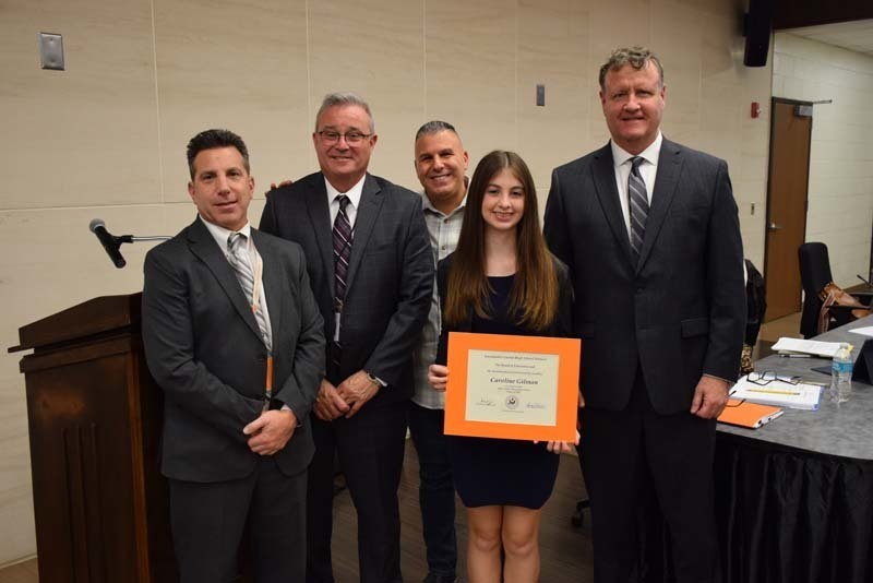 BOE members with a student holding a certificate