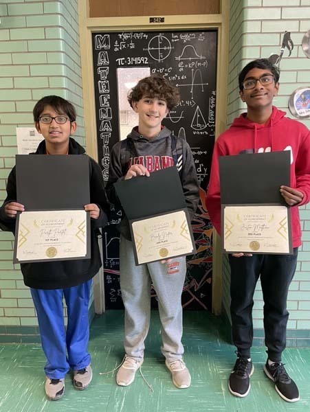 Students holding certificates and smiling at the camera