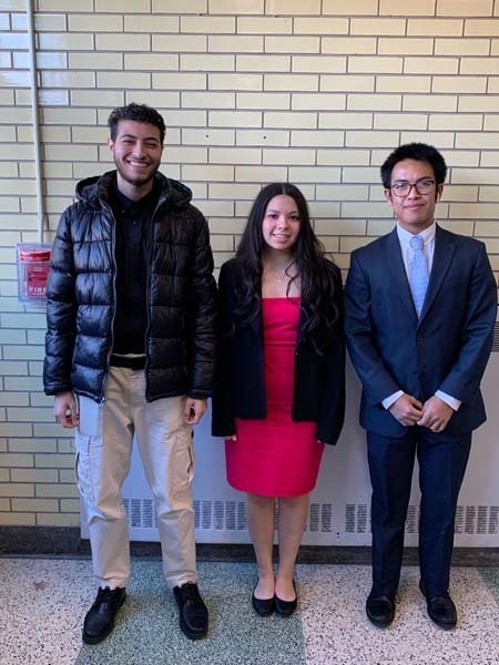 Three students smiling at the camera