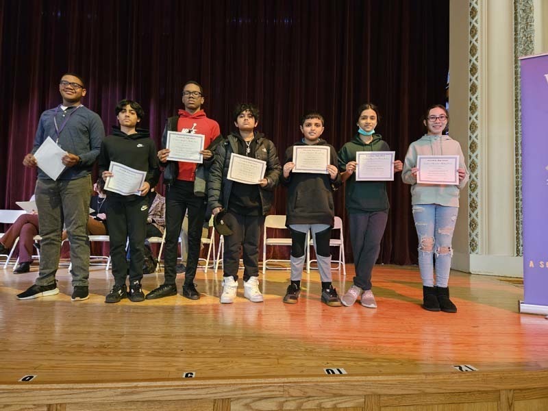 Students holding certificates and smiling