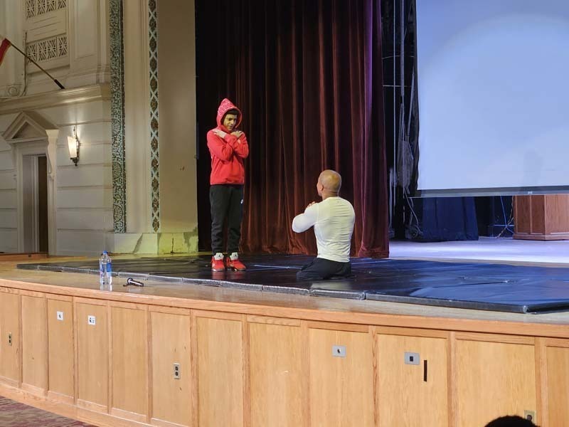Rohan Murphy talking with a student on stage