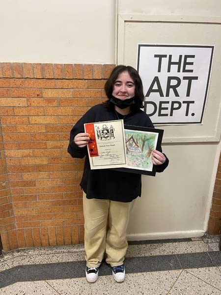 Jade Trask holding their artwork and award
